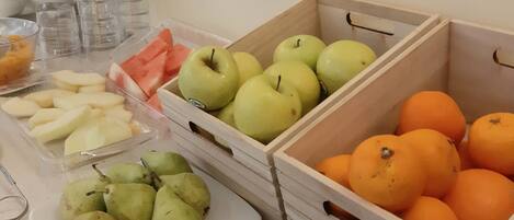 A fruit display with apples, oranges, and pears in wooden crates.