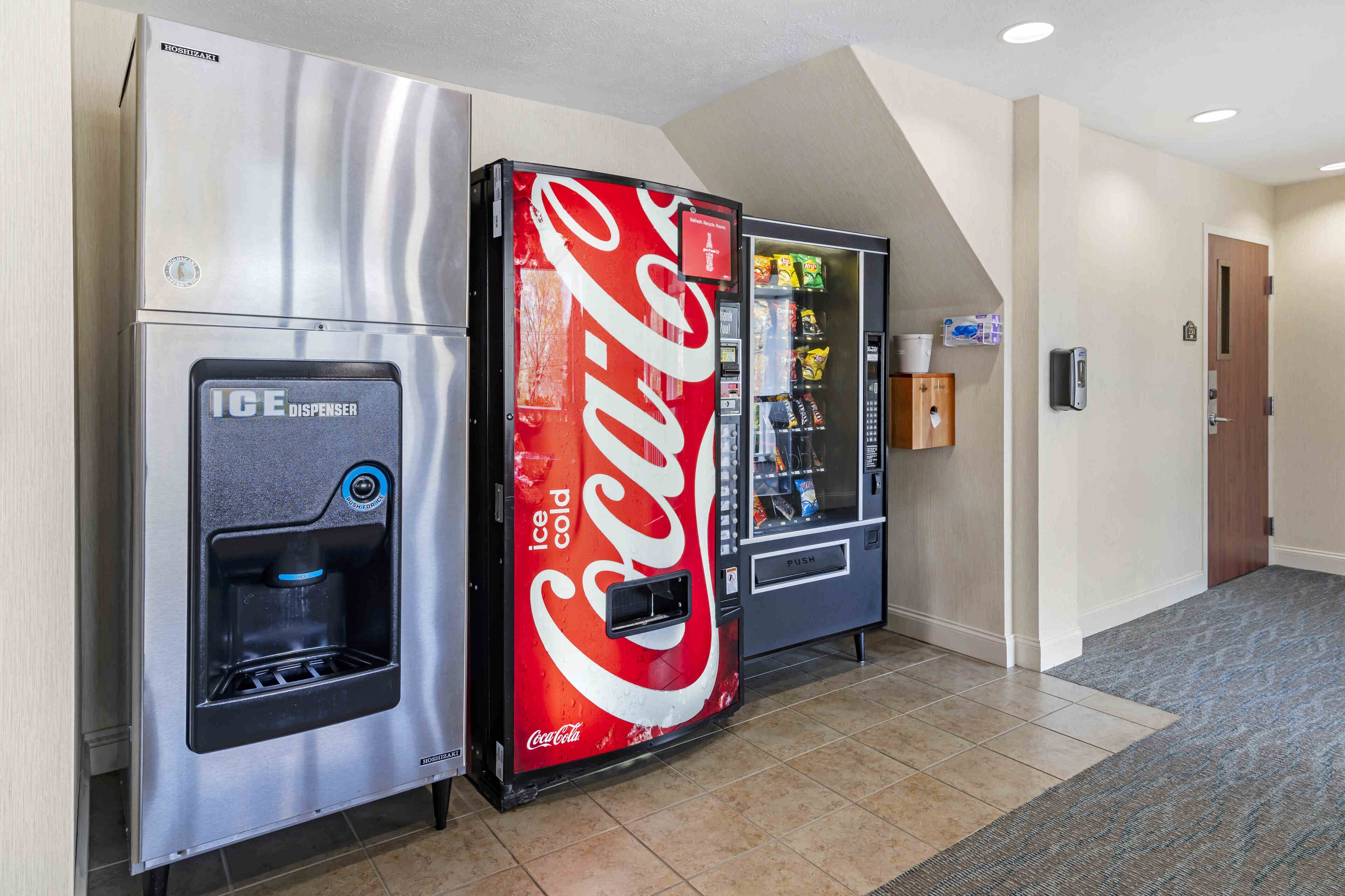 A vending machine area with an ICE dispenser and a Coca-Cola vending machine.