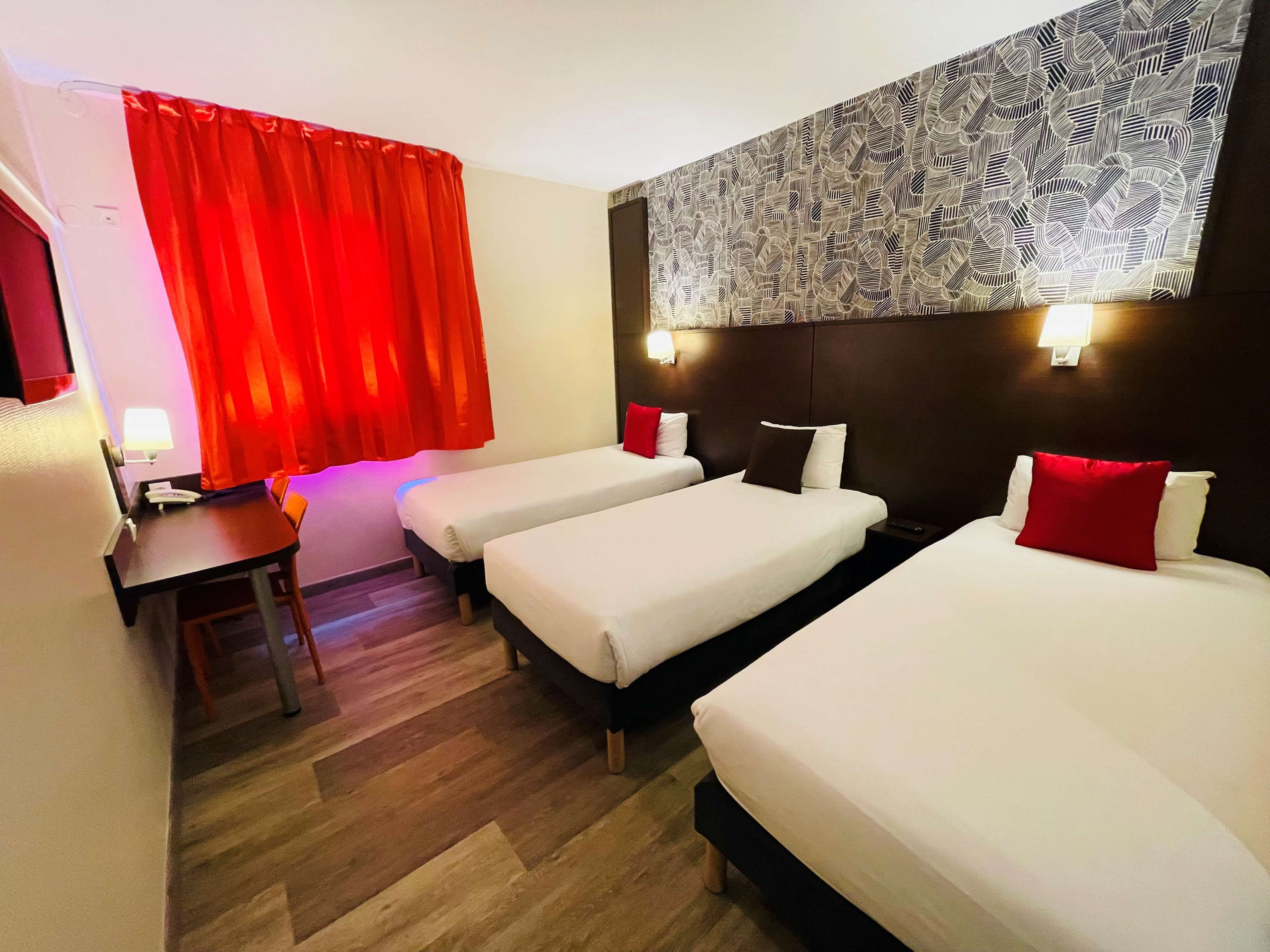 Una habitación de hotel con dos camas individuales, un escritorio y una silla.