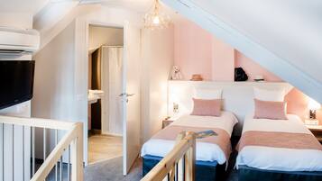 Cozy bedroom with two beds, a crib, and a TV, perfect for a family stay.
