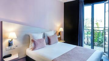 A modern hotel room with a large bed, two bedside lamps, a nightstand, and a view of the outdoors.