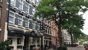 A hotel with a black and white facade, a prominent sign, and a row of parked bicycles. - Boutique Hotel Asterisk, a family run hotel (Amsterdam)