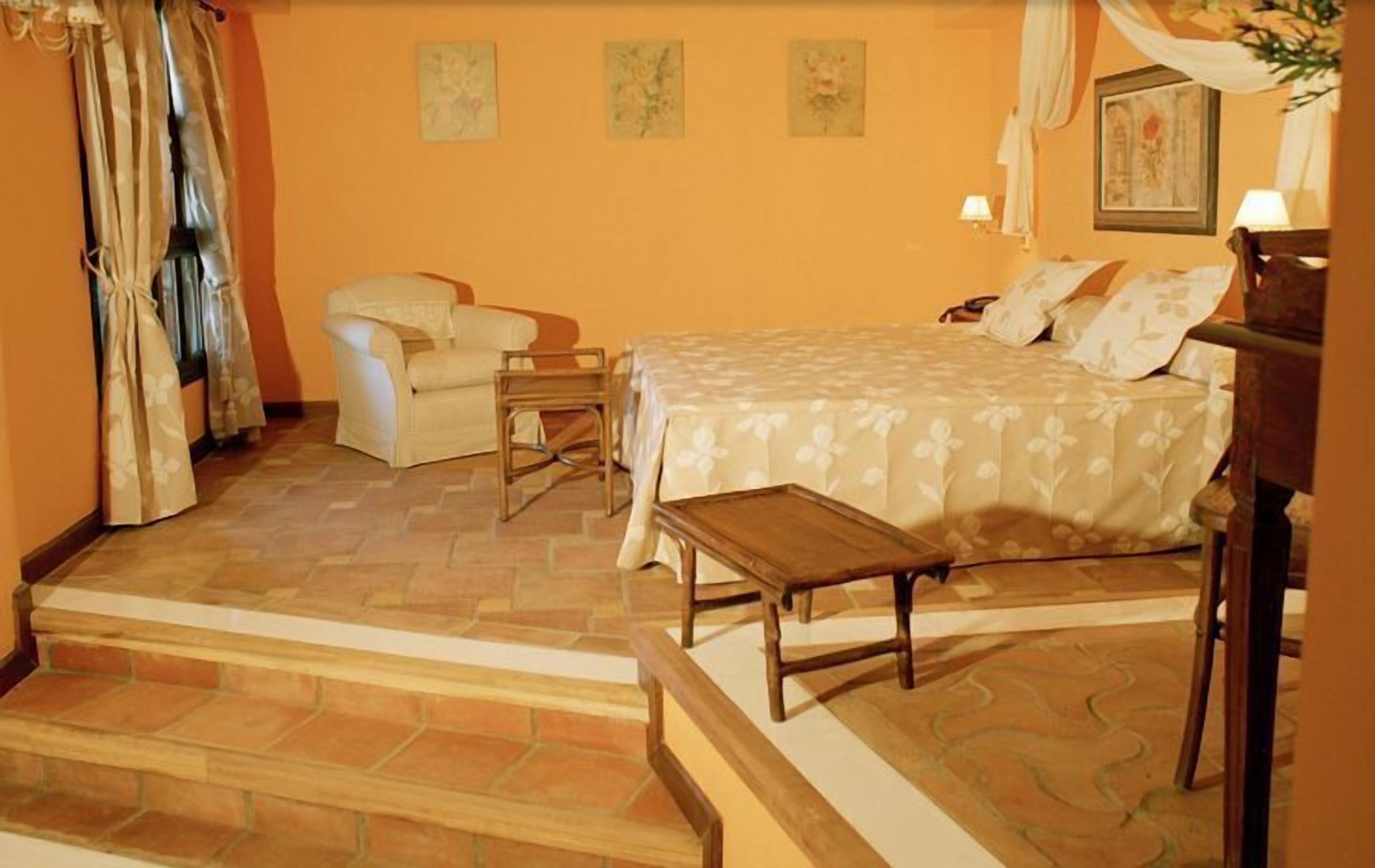 Une chambre à coucher avec un lit, une chaise, une petite table et un escalier.