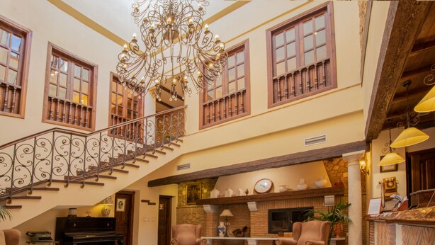 A spacious lobby with a grand staircase, a fireplace, and a piano.