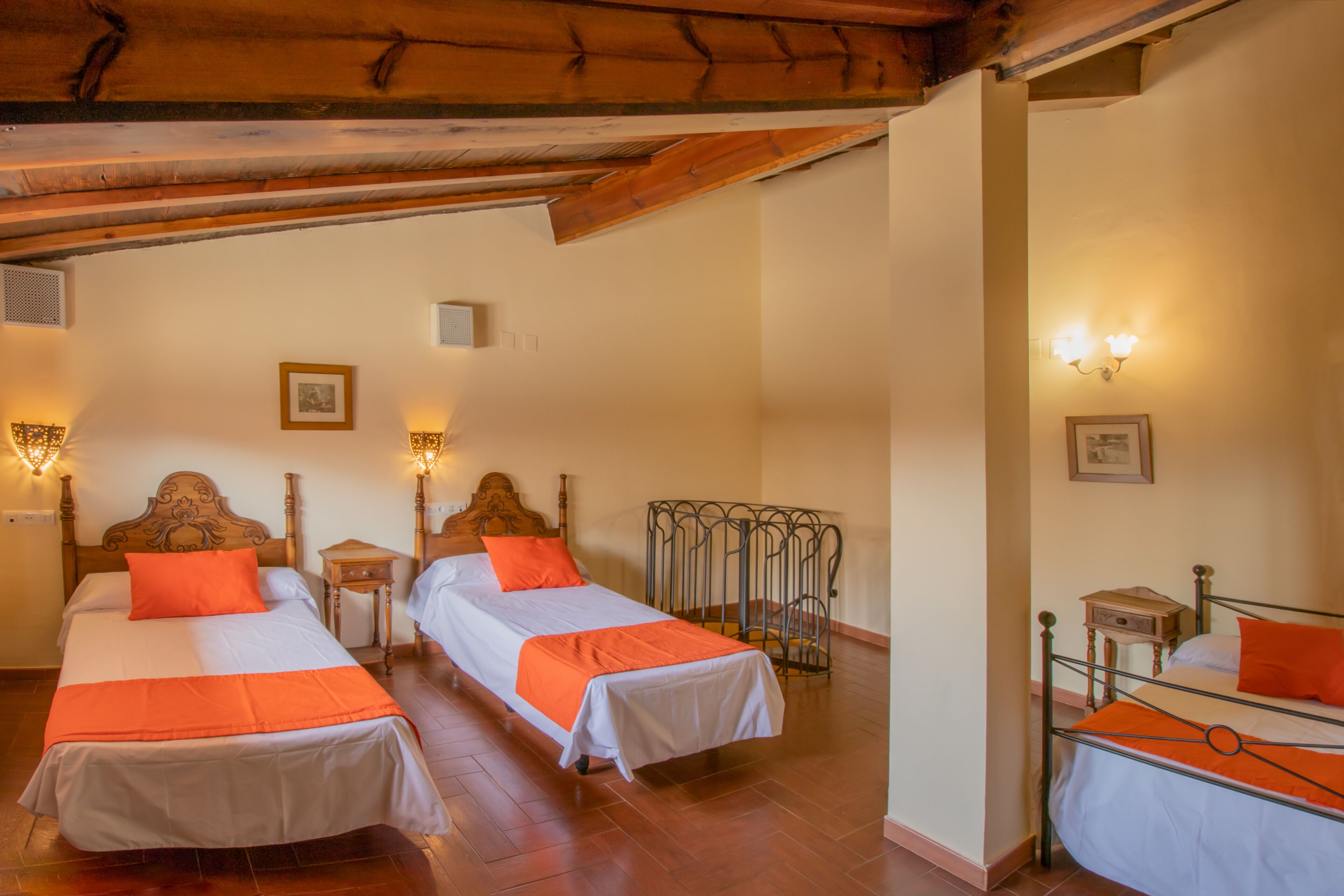 Quarto de hotel com duas camas de solteiro, cabeceiras de madeira e estrutura de metal.