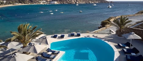 Una piscina al aire libre de temporada, sombrillas, tumbonas