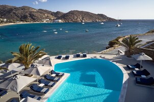 Una piscina al aire libre de temporada, sombrillas, tumbonas