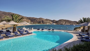 Una piscina al aire libre de temporada, sombrillas