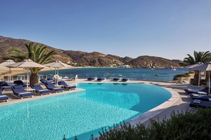 Una piscina al aire libre de temporada, sombrillas