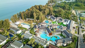 Un resort con múltiples piscinas, una piscina central amplia y una zona de playa.