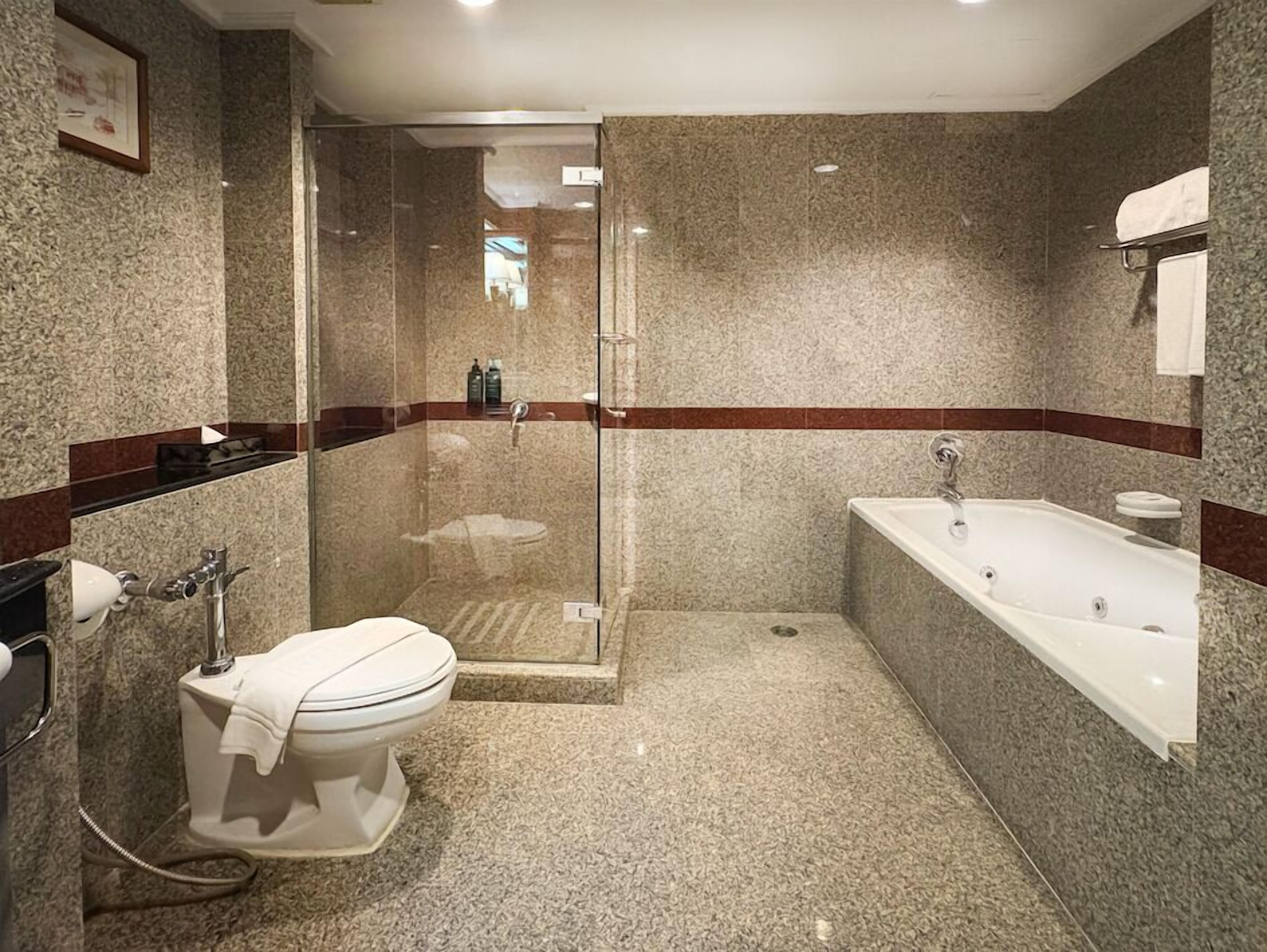 Ein modernes Badezimmer mit einer einteiligen Duschkabine, einer separaten Toilette und einer freistehenden Badewanne.