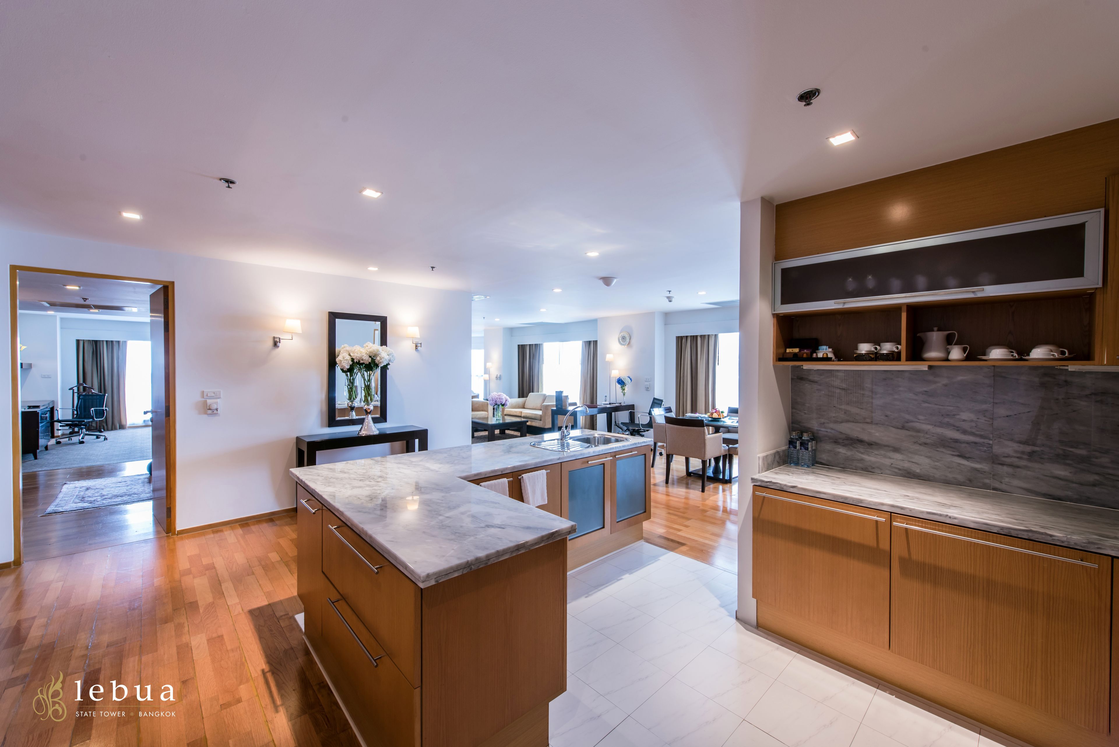 A modern kitchen with wooden cabinets, a marble countertop, and a built-in oven.