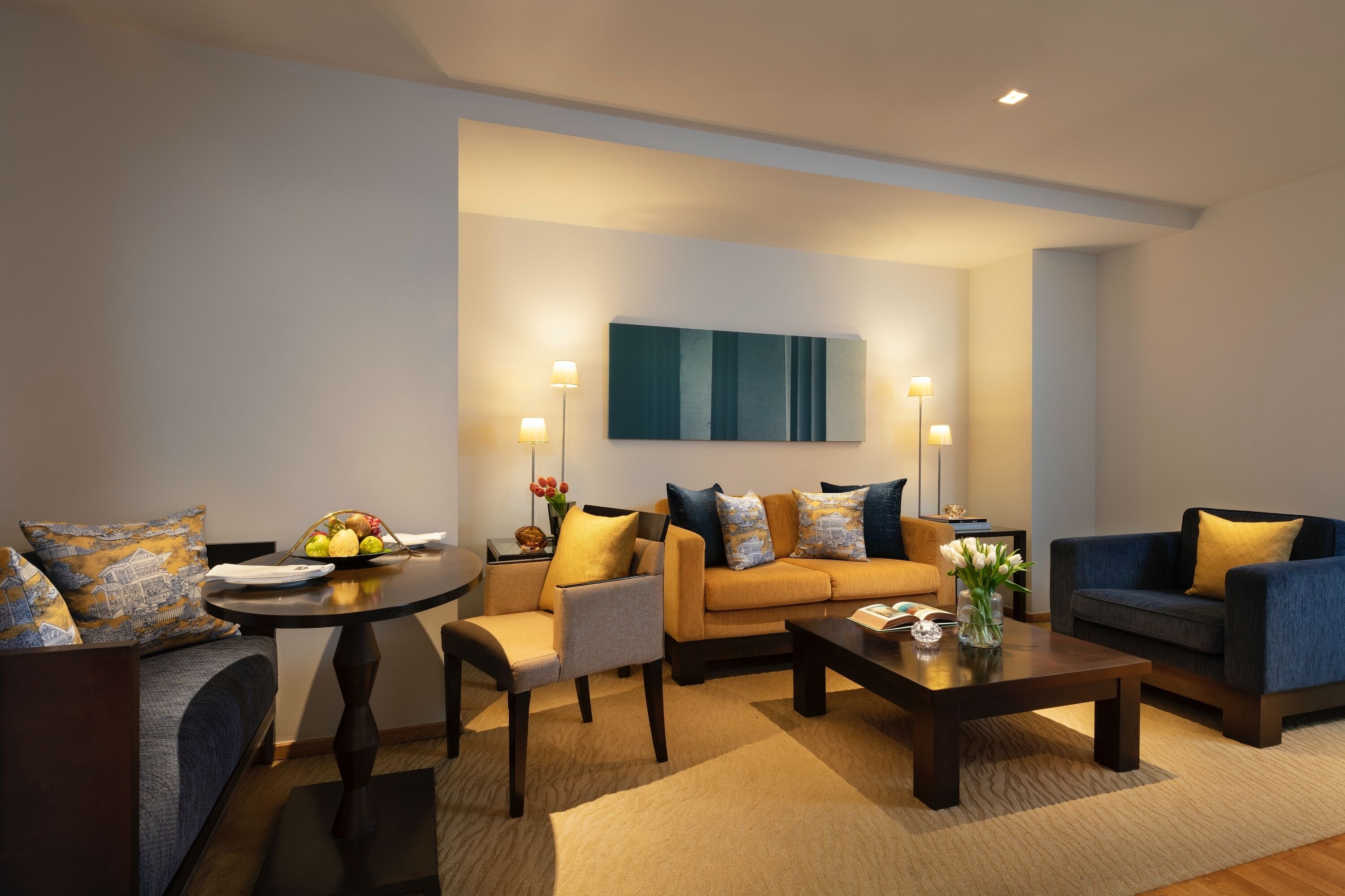 Una sala moderna con sofá, sillones, una mesa de centro y una mesa de comedor.