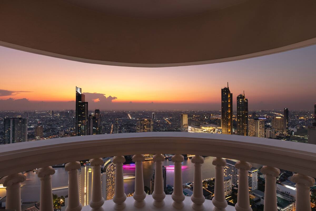 A balcony with a city view at sunset.