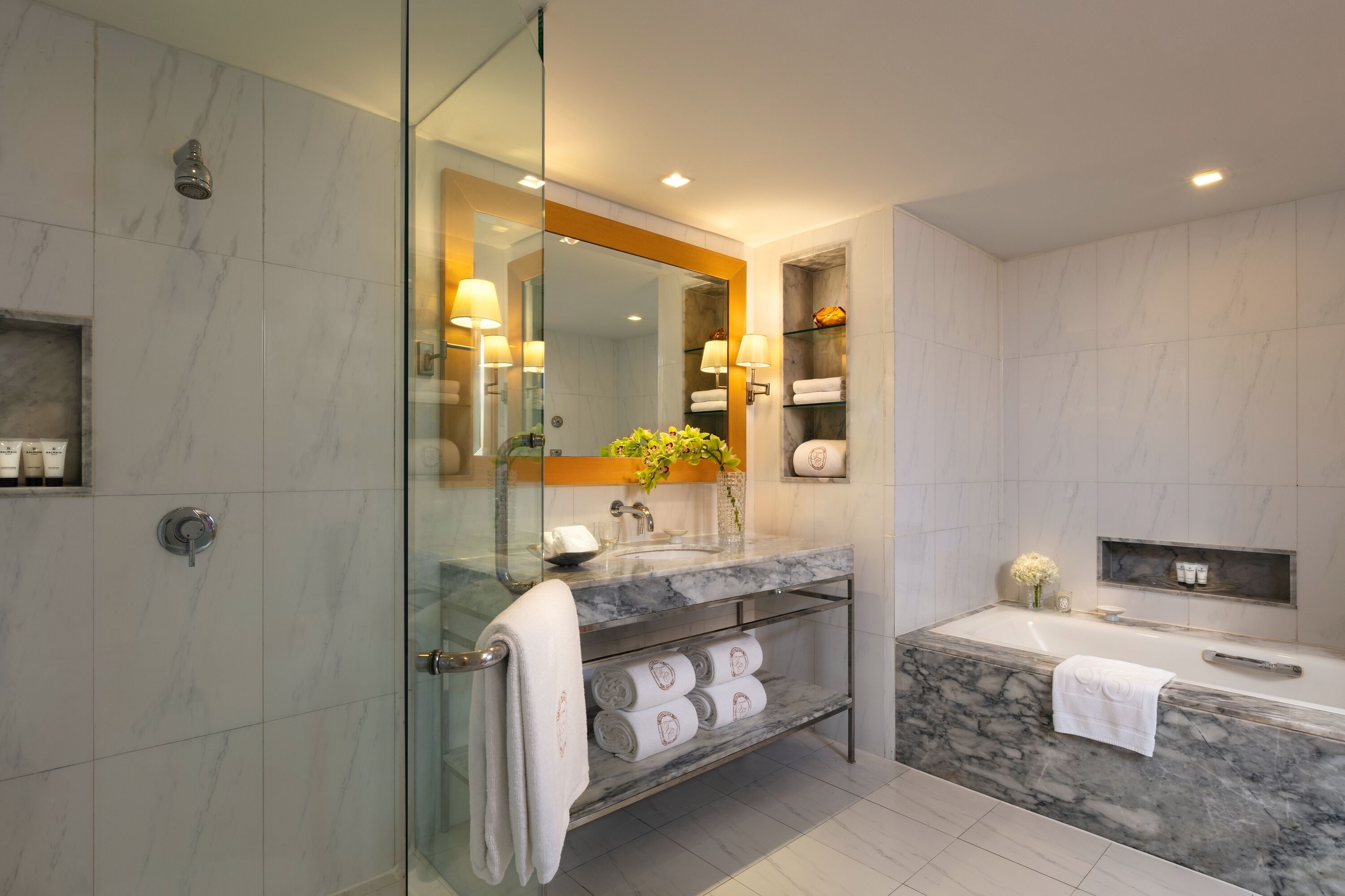 Ein modernes Badezimmer mit einer Glaskabine zur Dusche, einem мраморный Waschtisch und einer integrierten Badewanne.