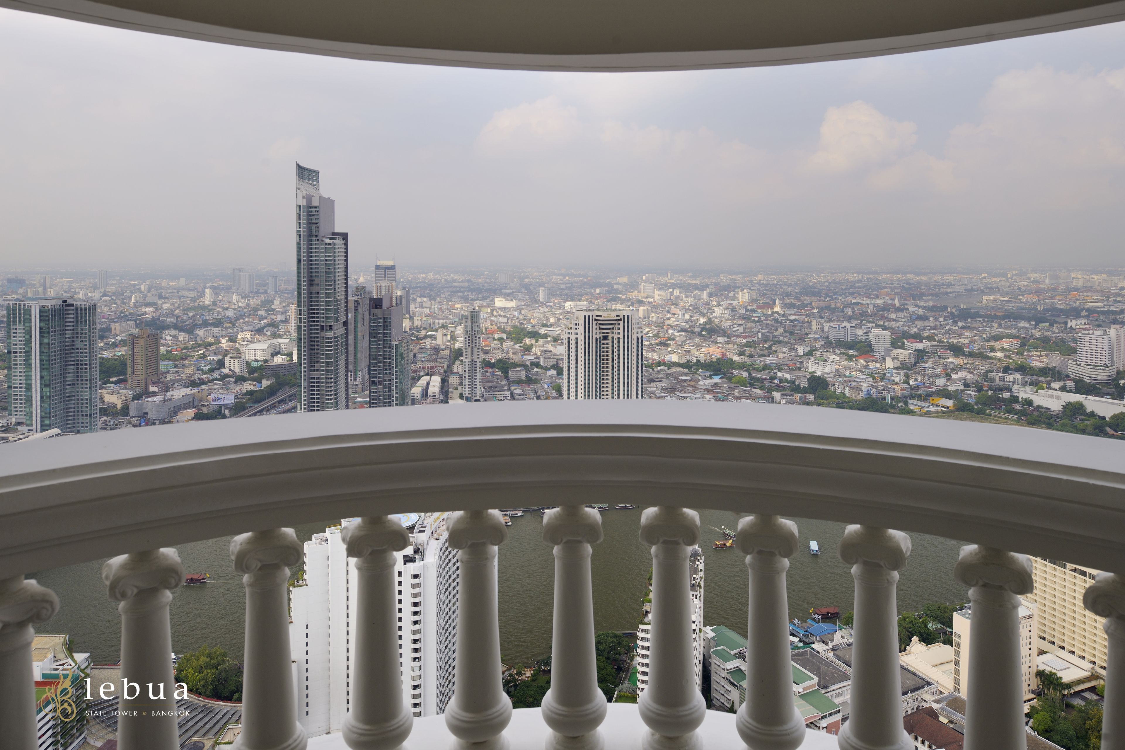 A high-rise building with a view of a cityscape and a river.