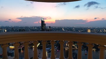 A cityscape at dusk with a view of a river and illuminated buildings.