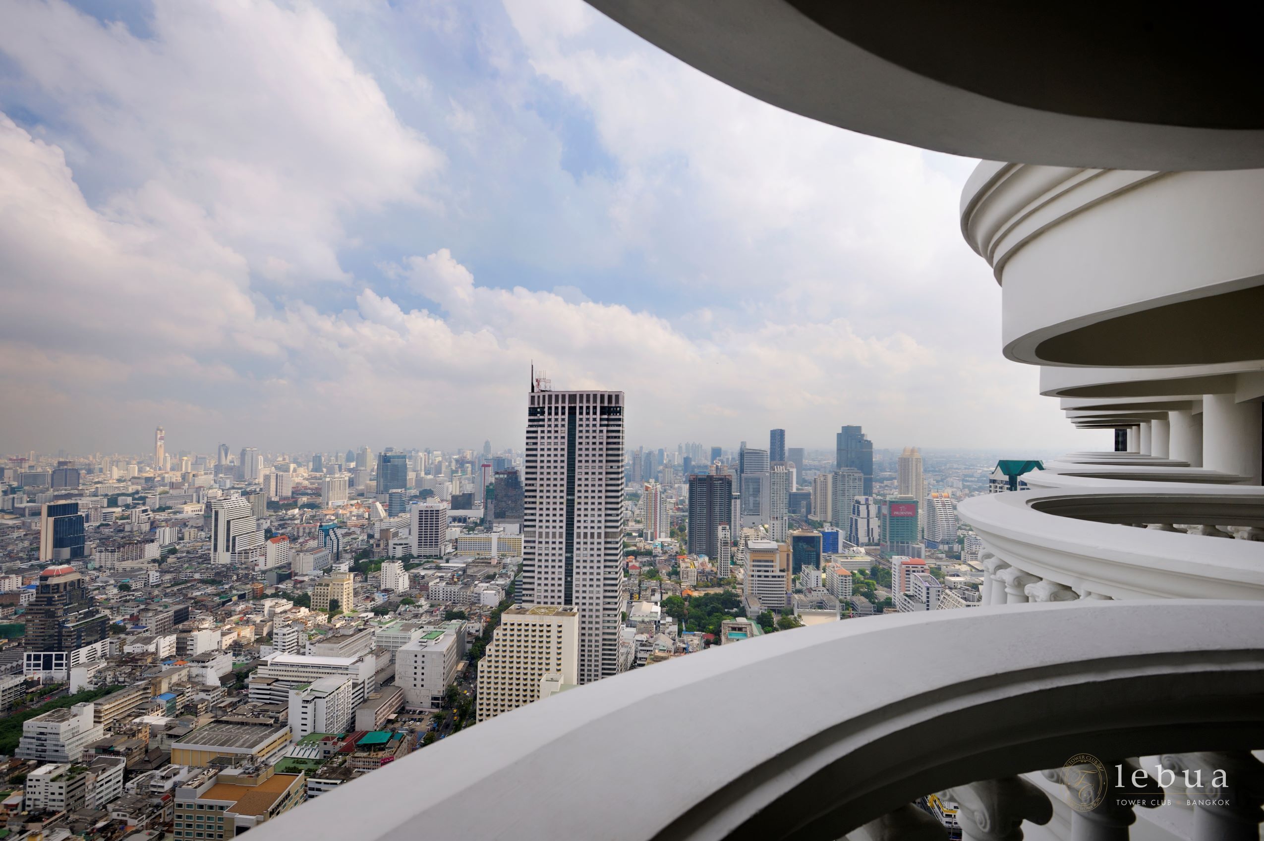 A cityscape with a prominent skyscraper and a modern building with a curved facade.