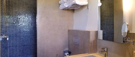 A bathroom with a shower, toilet, and two sinks.