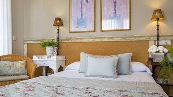 A neatly arranged bedroom with a bed, two bedside tables, a chair, and two wall-mounted lamps.