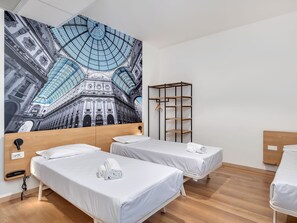 Ein Hotelzimmer mit zwei Betten, einem Kleiderschrank und einem großflächigen Wandbild eines Gebäudes.