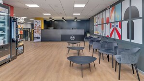L’intérieur d’un café moderne, avec un comptoir d’accueil, un espace salon et un présentoir pour les aliments.