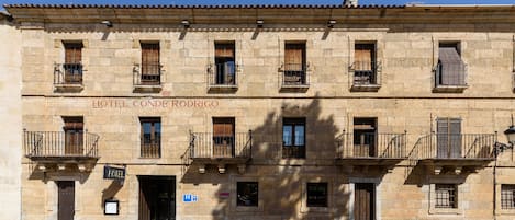 Un edificio histórico con varios balcones y un letrero que dice "HOTEL CONDE RODRIGO".