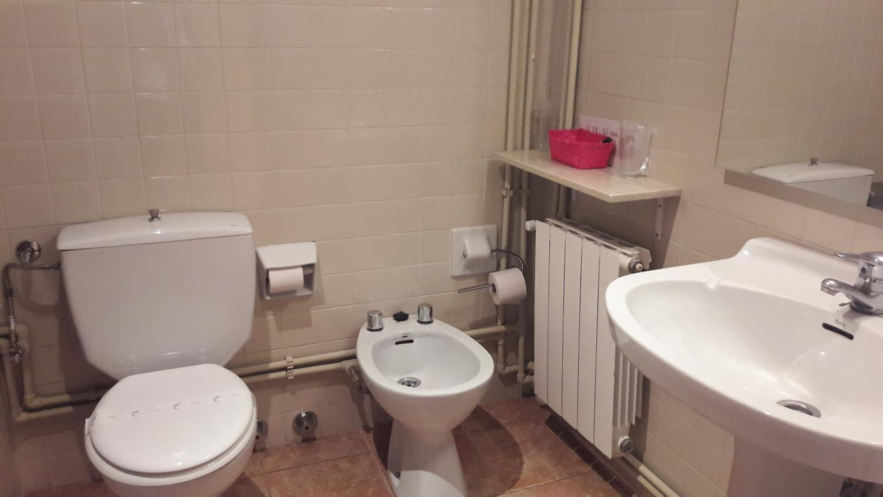 A bathroom with a toilet, bidet, and sink.