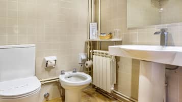Un baño con inodoro, bidé y lavamanos.