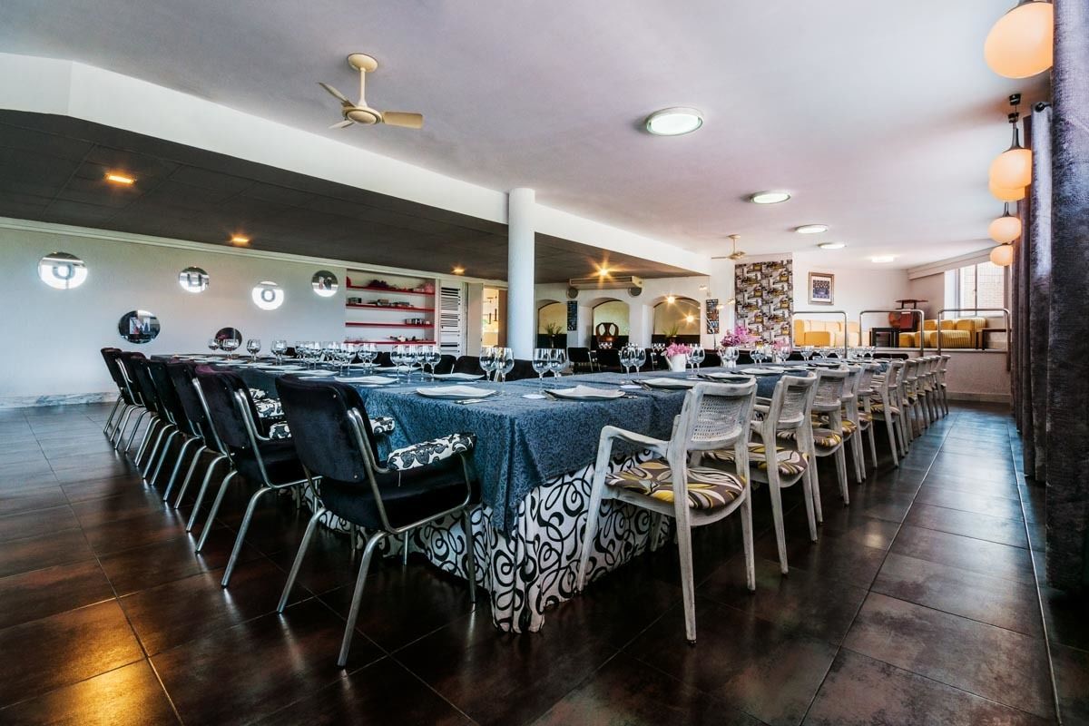 A spacious dining area with multiple round tables, each set with chairs and table settings.