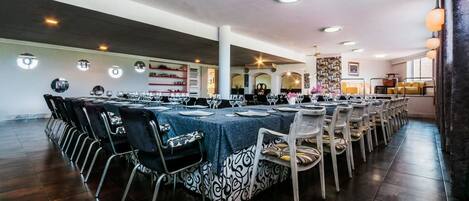 A spacious dining area with multiple round tables, each set with chairs and table settings.
