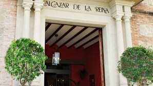 La façade d’un immeuble sur laquelle on peut lire l’inscription « ALCazar de la Reina » au-dessus de l’entrée.