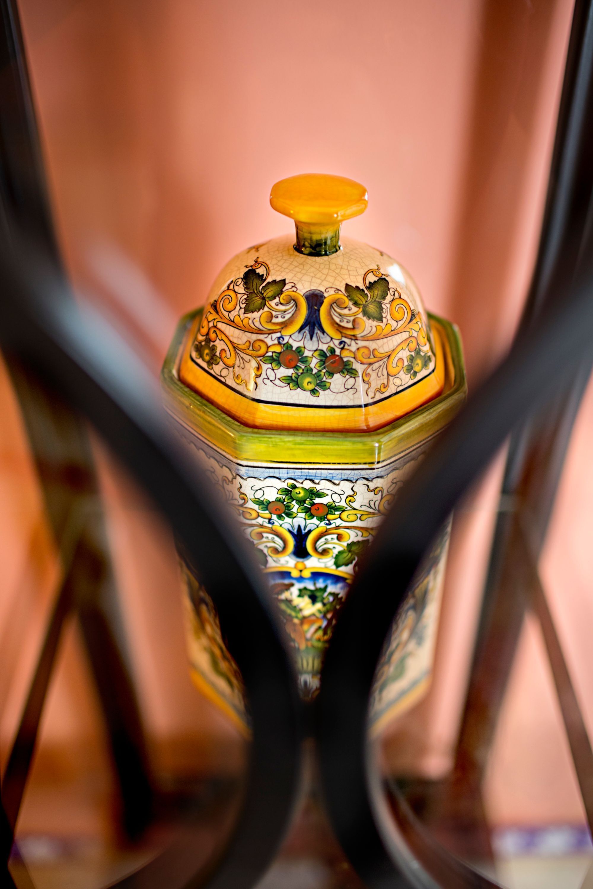 A close-up of a decorative ceramic container with intricate designs, featuring a lid with a knob.