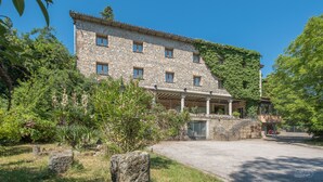 A stone building with multiple windows and a covered porch.