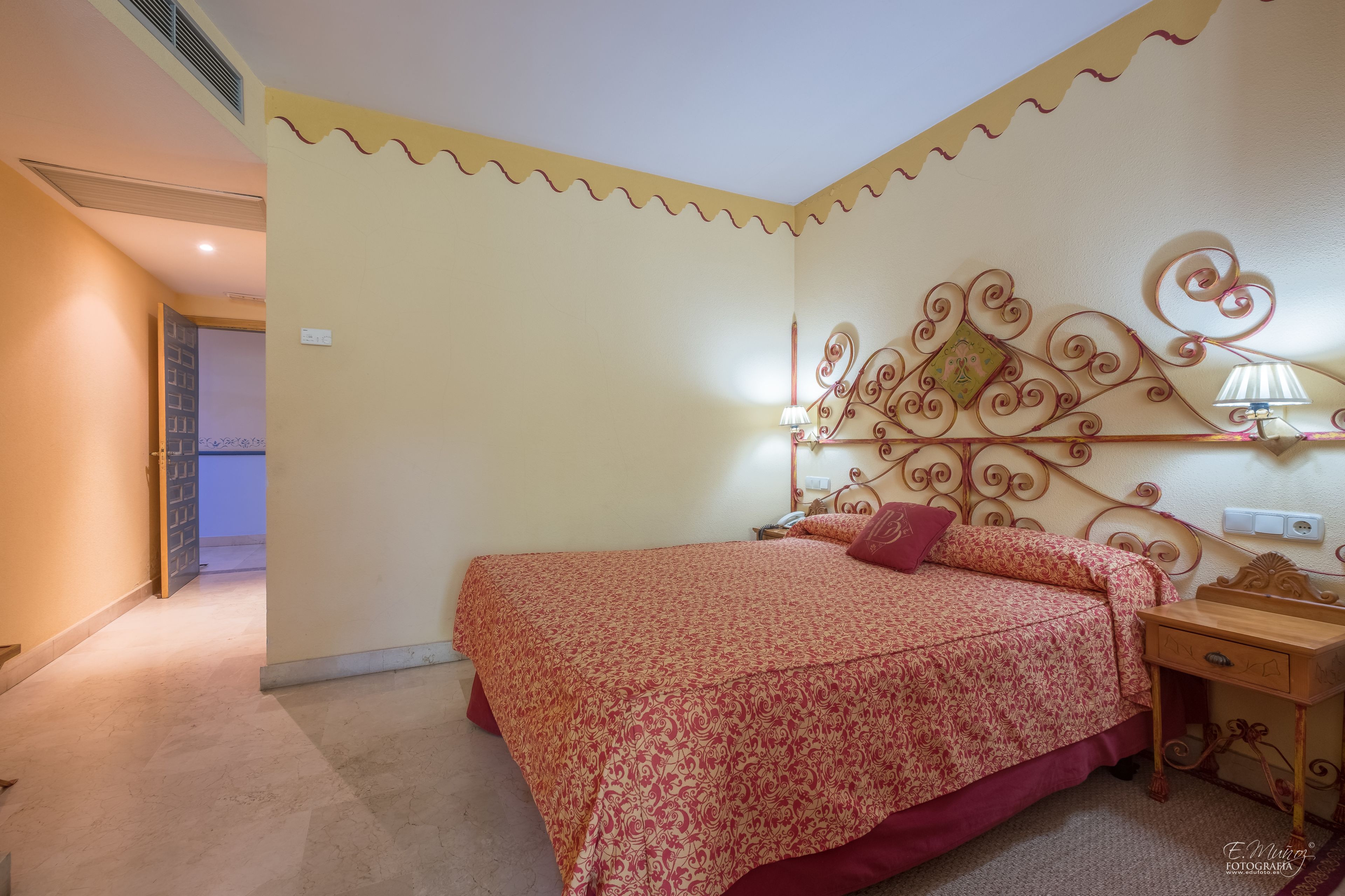 Ein Schlafzimmer mit Bett, Nachttisch und Wanddeko.