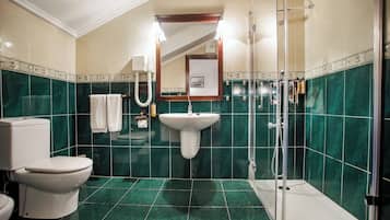 A bathroom with a toilet, sink, and shower.