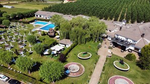 Vista aérea de un complejo turístico con piscina, varias zonas de descanso y un patio central con detalles decorativos.