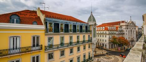 Un edificio de varios pisos con balcones, un patio central y vista a la calle.