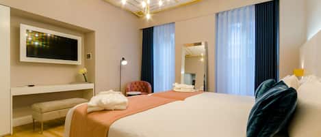A hotel room with a bed, a desk, a chair, a TV, and a mirror.