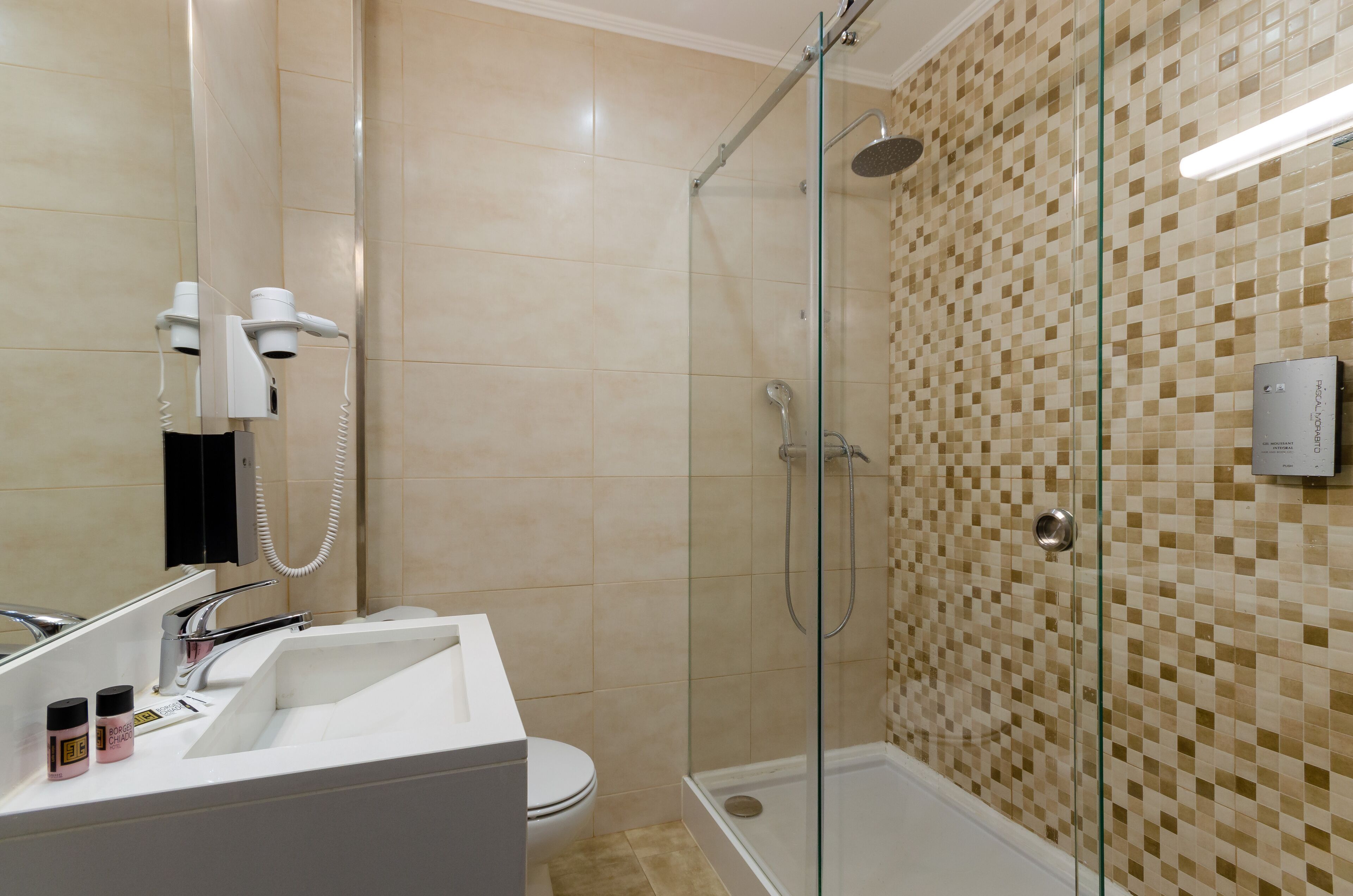 A modern bathroom with a glass shower enclosure, a white sink, and a toilet.