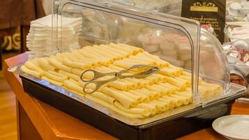 Un bufé con una cubierta de vidrio transparente, que contiene rollos de pasta ordenados y un par de tijeras en la bandeja.