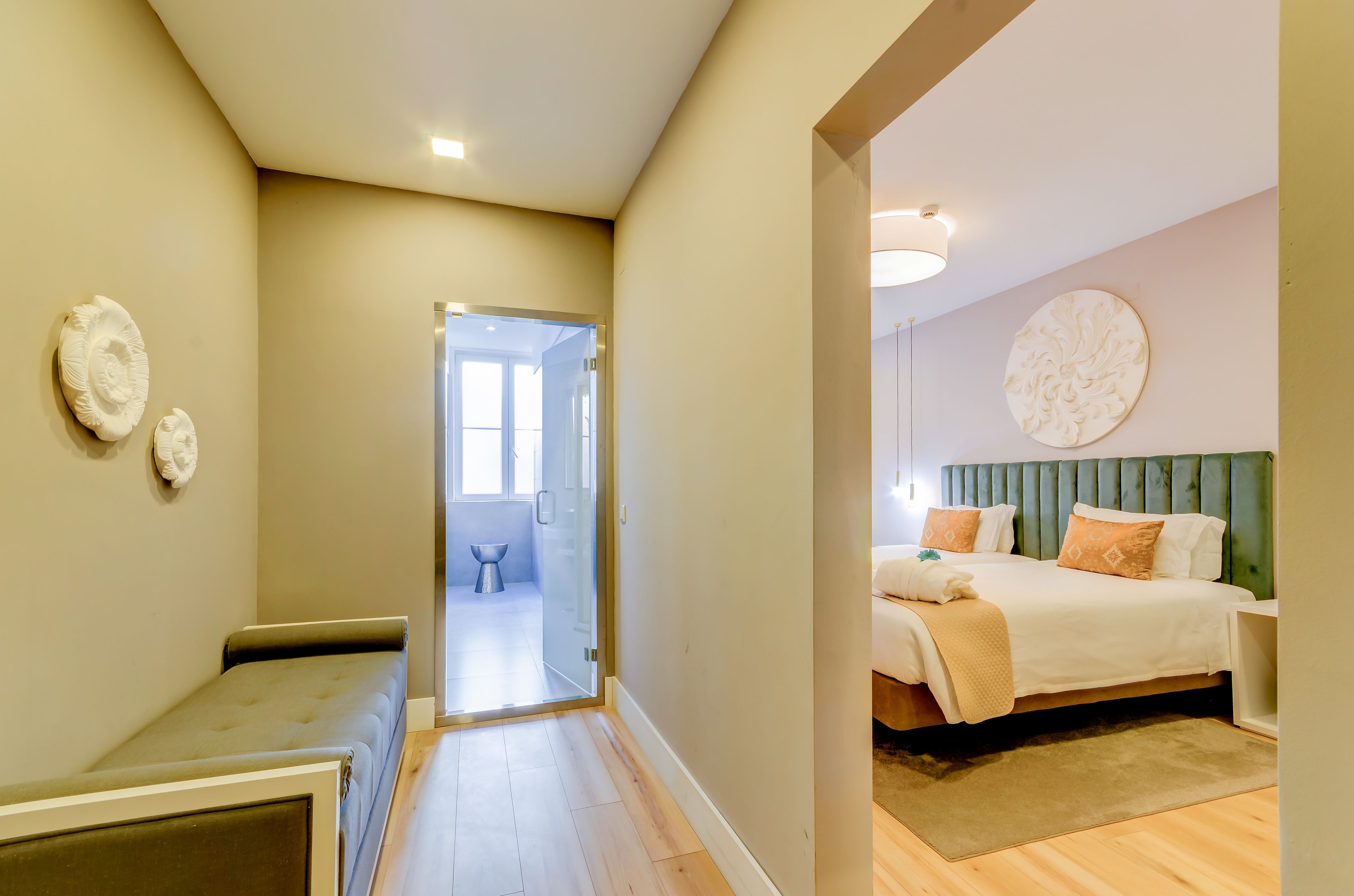Une chambre à coucher avec un lit, une table de chevet et une commode. Une porte donne accès à la salle de bain.