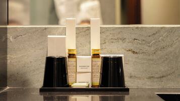 A bathroom counter with a shower cap and body lotion dispenser.