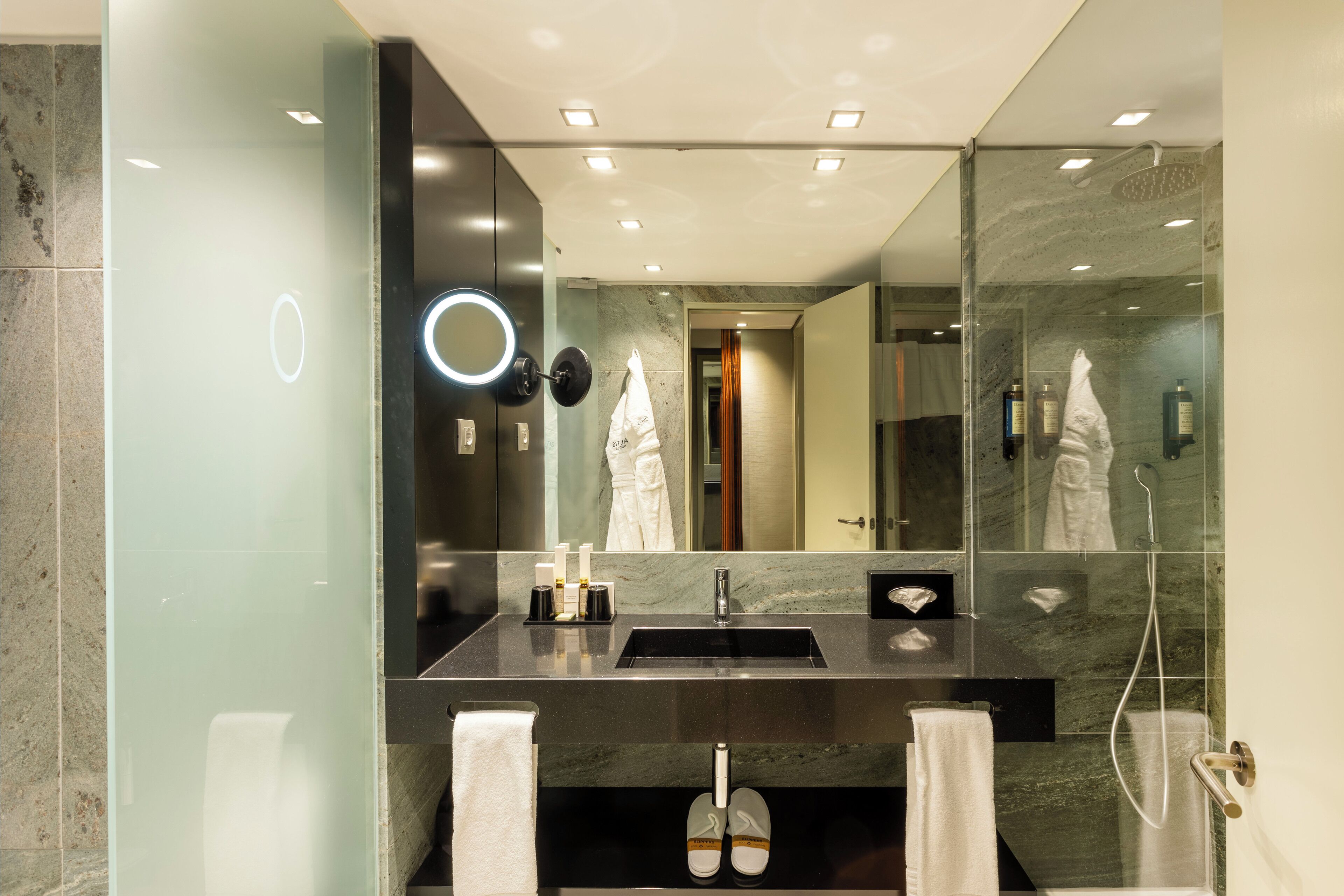 Un baño moderno con un espejo grande, un lavabo y una ducha.