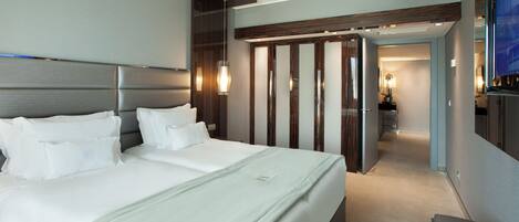 Una habitación de hotel moderna con una cama grande, un vestidor y un televisor.
