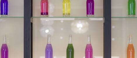 Una exhibición de botellas de vidrio de colores en una vitrina.