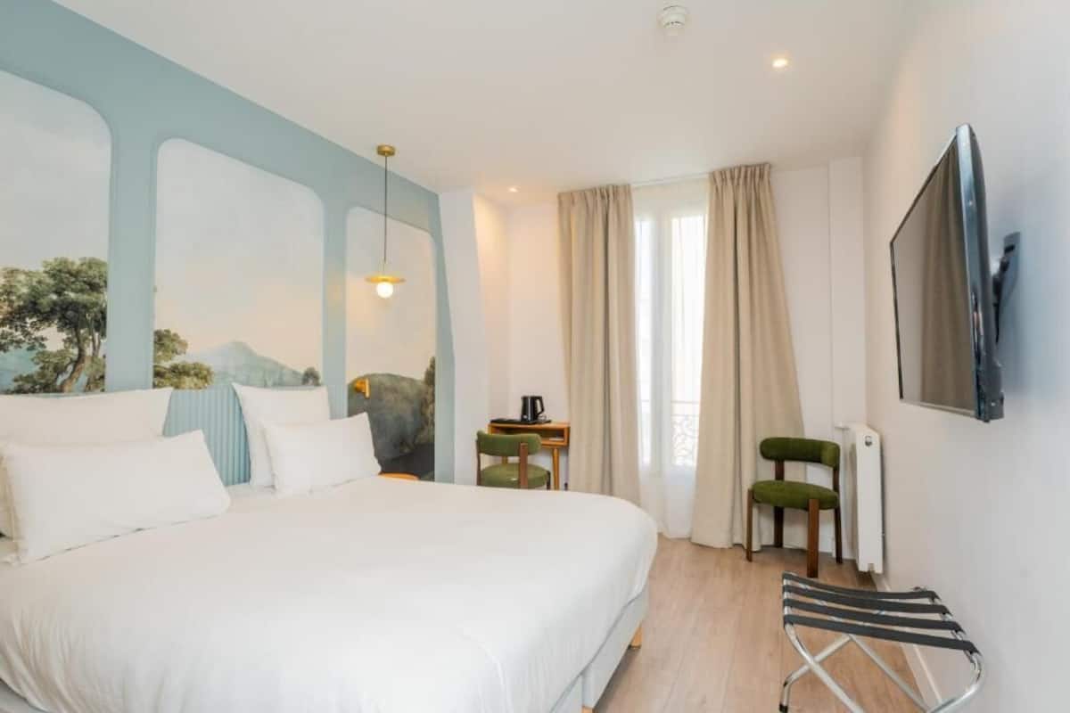 Une chambre à coucher comprenant un lit, un bureau, une chaise, un radiateur et un téléviseur fixé au mur.