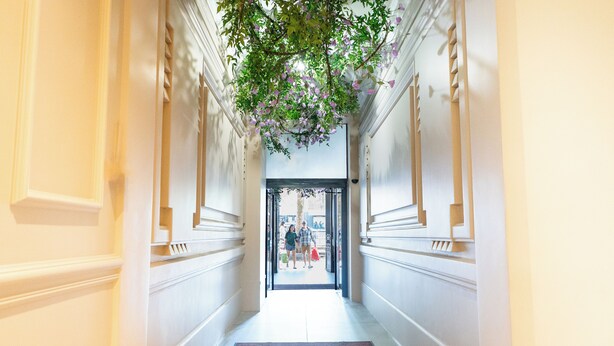 A hallway with a marble floor, white walls, and a door at the end. - BOBO'S HÔTEL  (Paris)