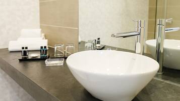 A modern bathroom with a white vessel sink, chrome fixtures, and a mirror reflecting the space.