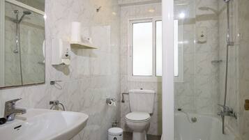 Un baño con lavamanos, inodoro y ducha.